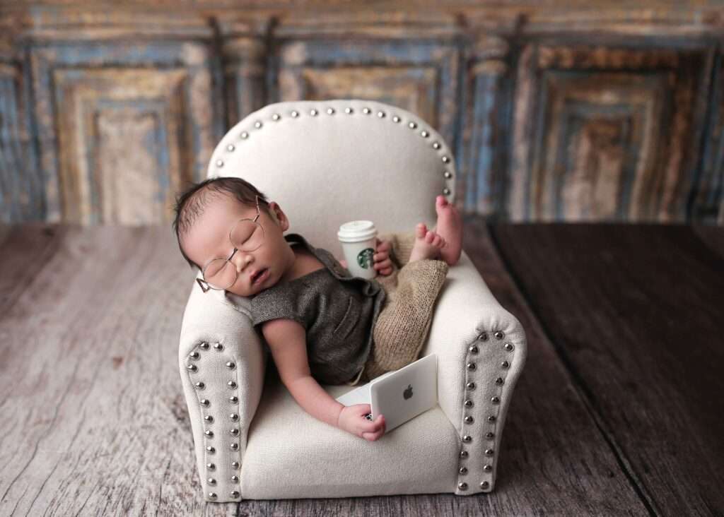 NEWBORN boy laying in chair, working on computer and coffee